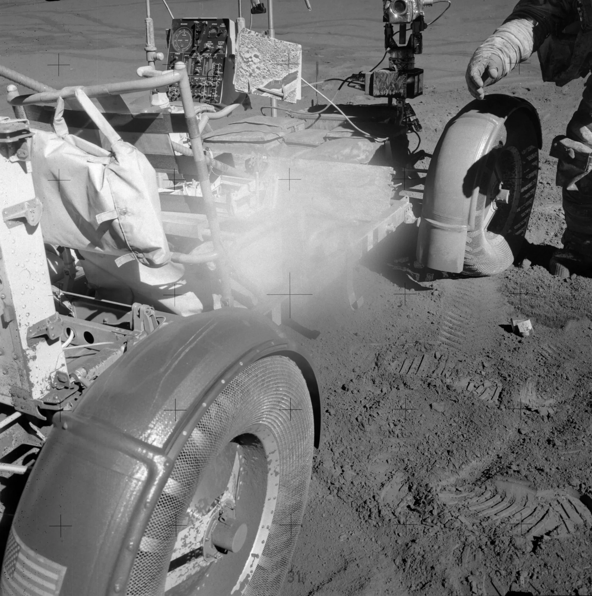 Dust covers the central part of the lens in this photograph, obscuring the subject. The photo is of a dust-covered lunar rover. Dust can be seen caking the wheel rims and bodywork, as well as the astronaut’s suit in the top right of the image. <br />https://www.nasa.gov/history/alsj/picture.html