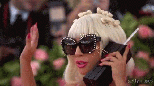 A gif of Lady Gaga holding an '80s style cell phone