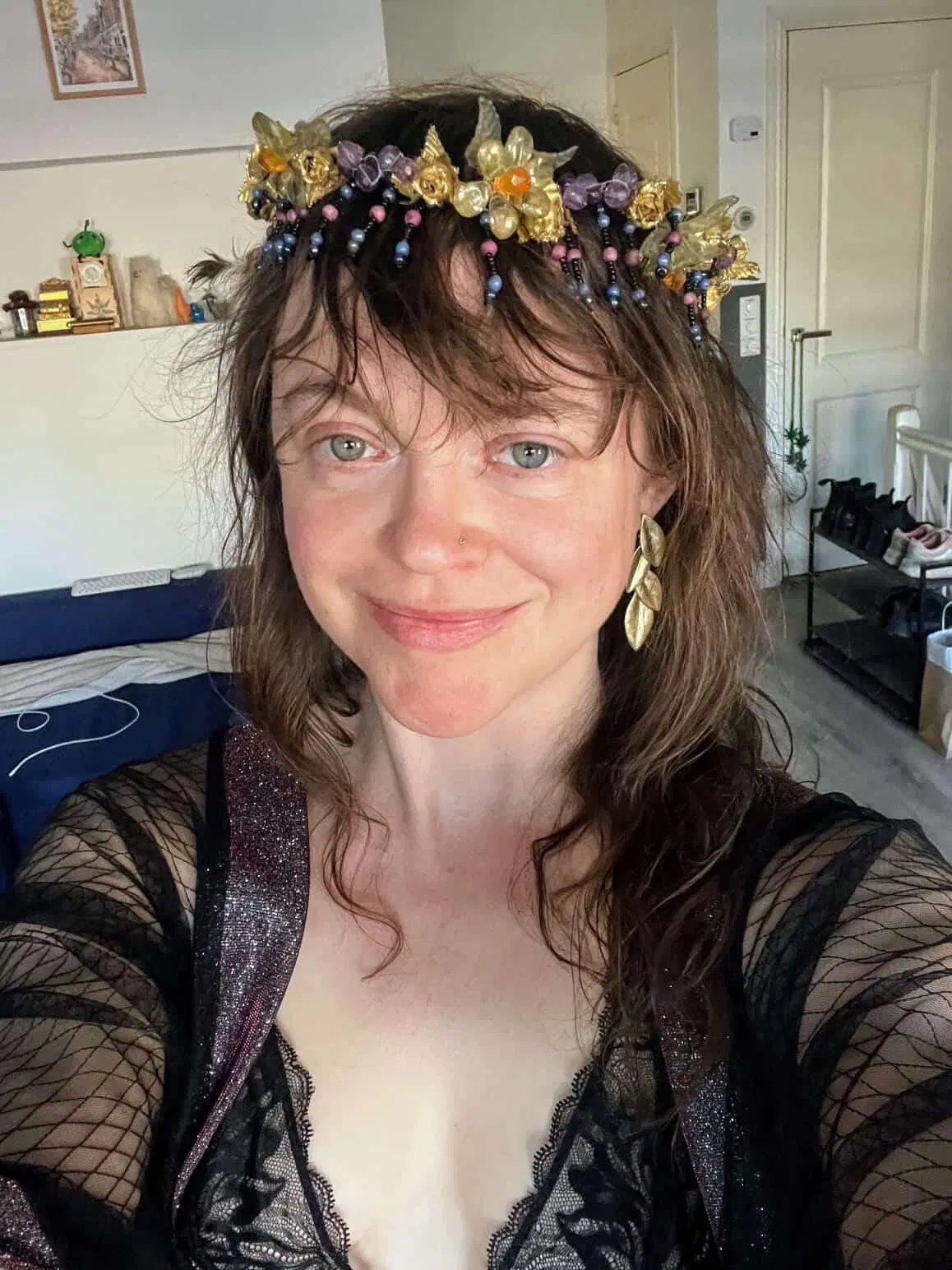 A selfie that Leeen took. She's wearing a sheer shawl that has glittery trim, a lacy bodysuit, a crown of flowers, and golden leaf earrings